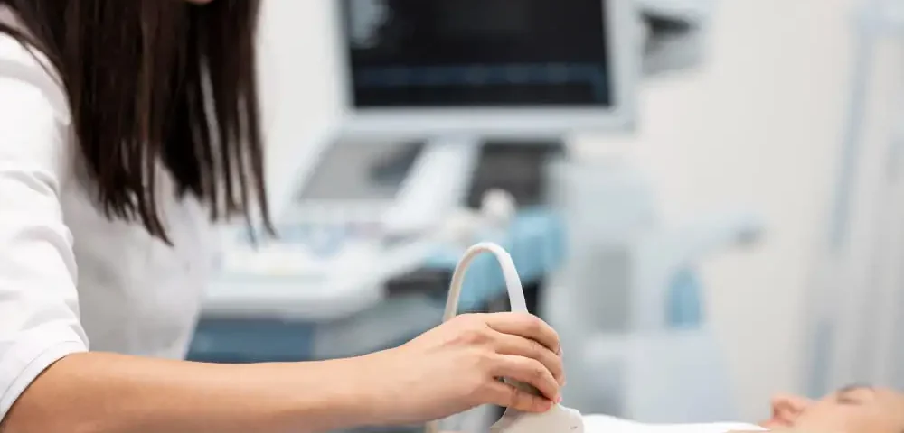 Un médecin utilise un échographe gynécologique sur une patiente