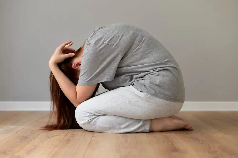 Une femme en crise d'angoisse se tenant la tête dans els mains