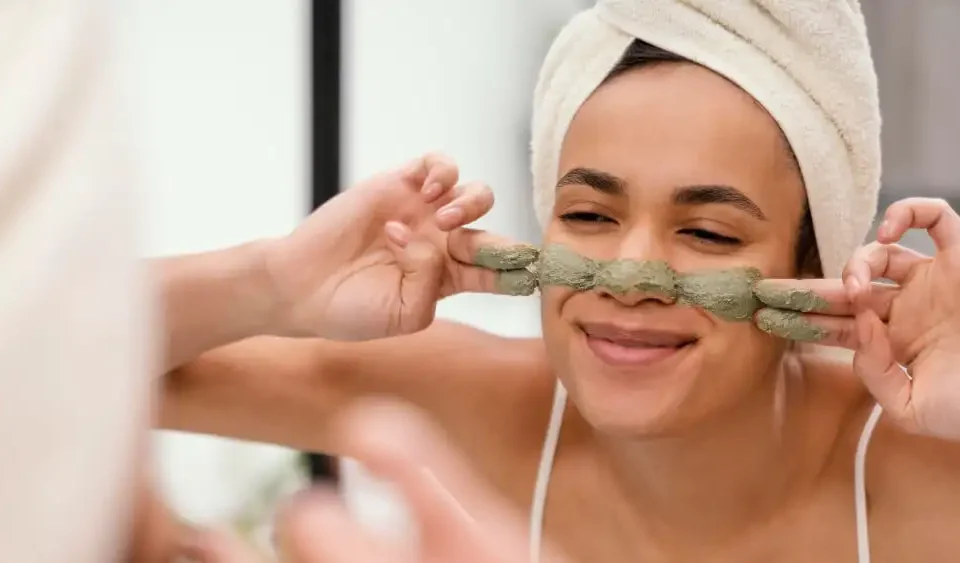 Une femme qui se fait un masque d'argile vert