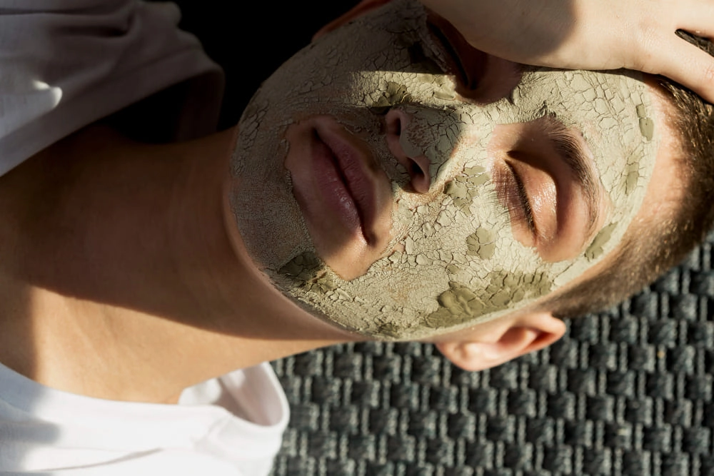 un masque d'argile vert séché sur le visage d'une femme